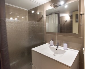 Appartement, 1 chambre | Salle de bain | Douche, sèche-cheveux, serviettes fournies, savon