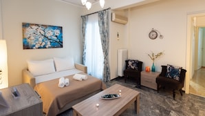 A modern hotel room with a bed, a wooden coffee table, a desk, and a chair. - Blue Ark Athenian Nest (Nea Smirni)