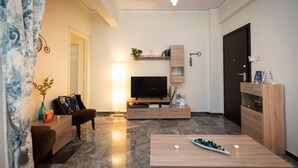 A modern living room with a flat-screen TV, wooden furniture, and a marble floor. - Blue Ark Athenian Nest (Nea Smirni)