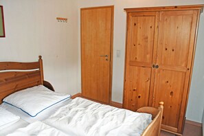 A bedroom with a wooden bed, a wardrobe, and a door.
