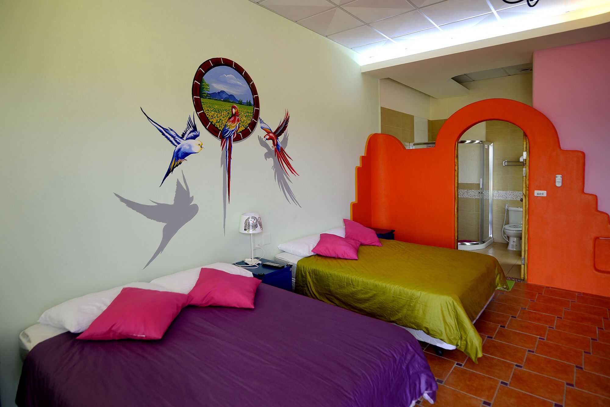 A hotel room with two beds, a shower, and a bathroom.