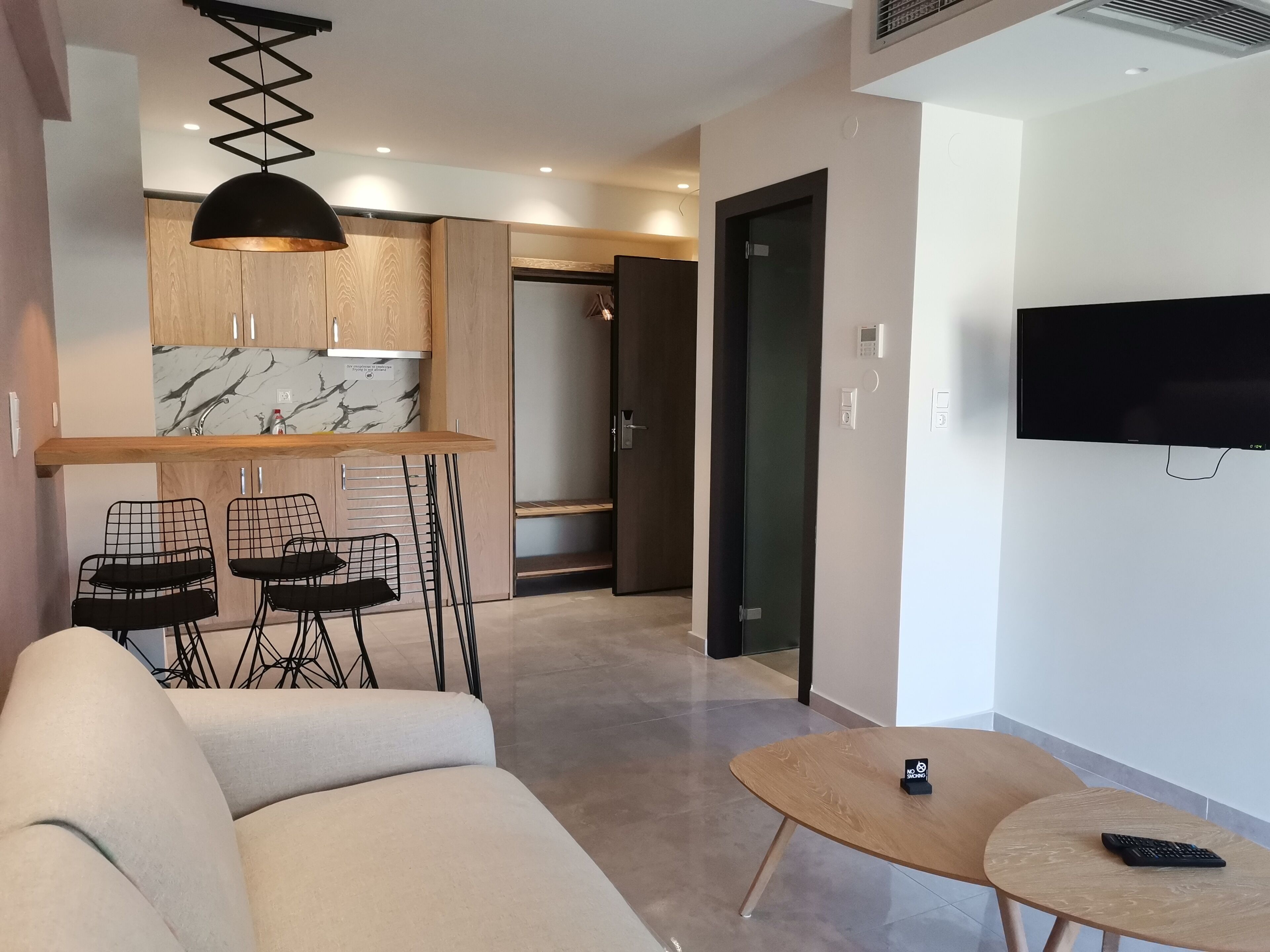 Un salon moderne avec un canapé, une table basse et un téléviseur fixé au mur.