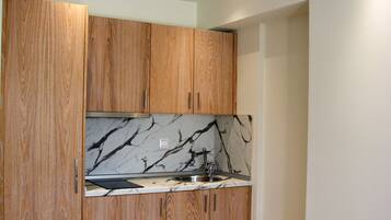 A kitchen with wooden cabinets and a marble backsplash.