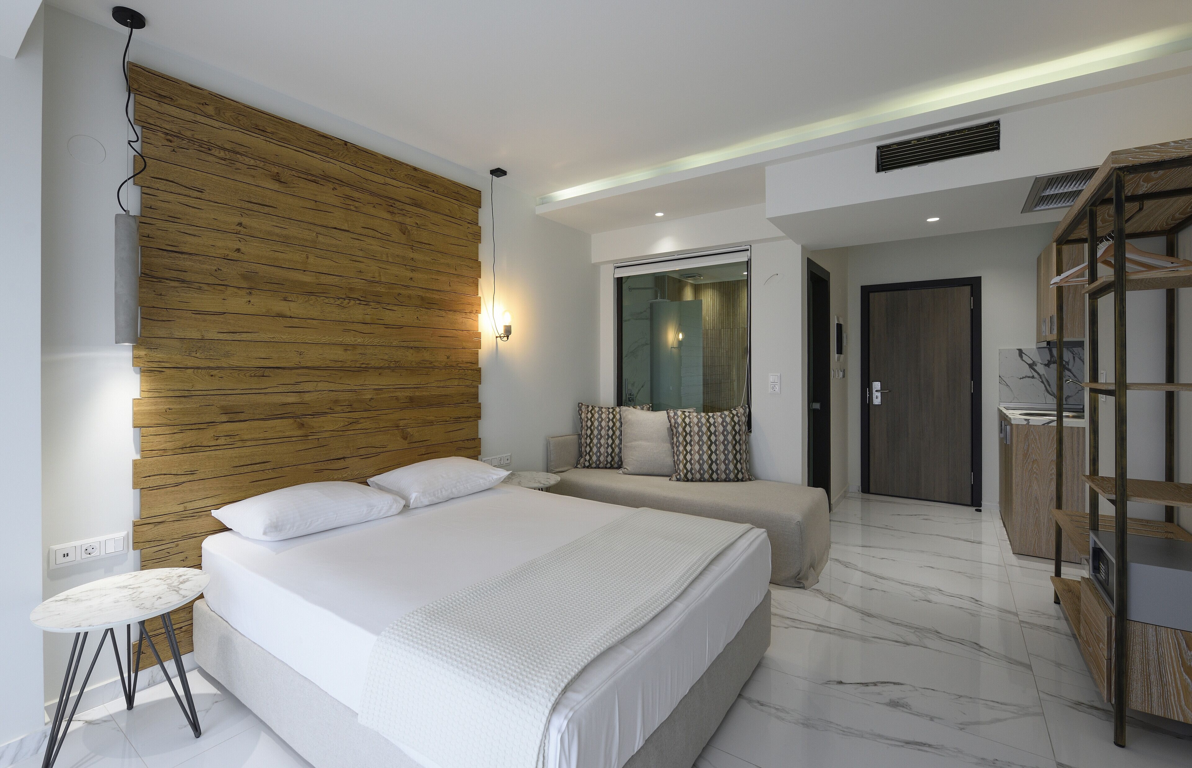 Quarto moderno com cama grande, mesas de cabeceira, painel de parede em madeira e armário embutido.