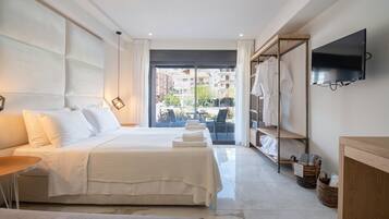 Una habitación de hotel con cama, escritorio, televisor y vistas al exterior.