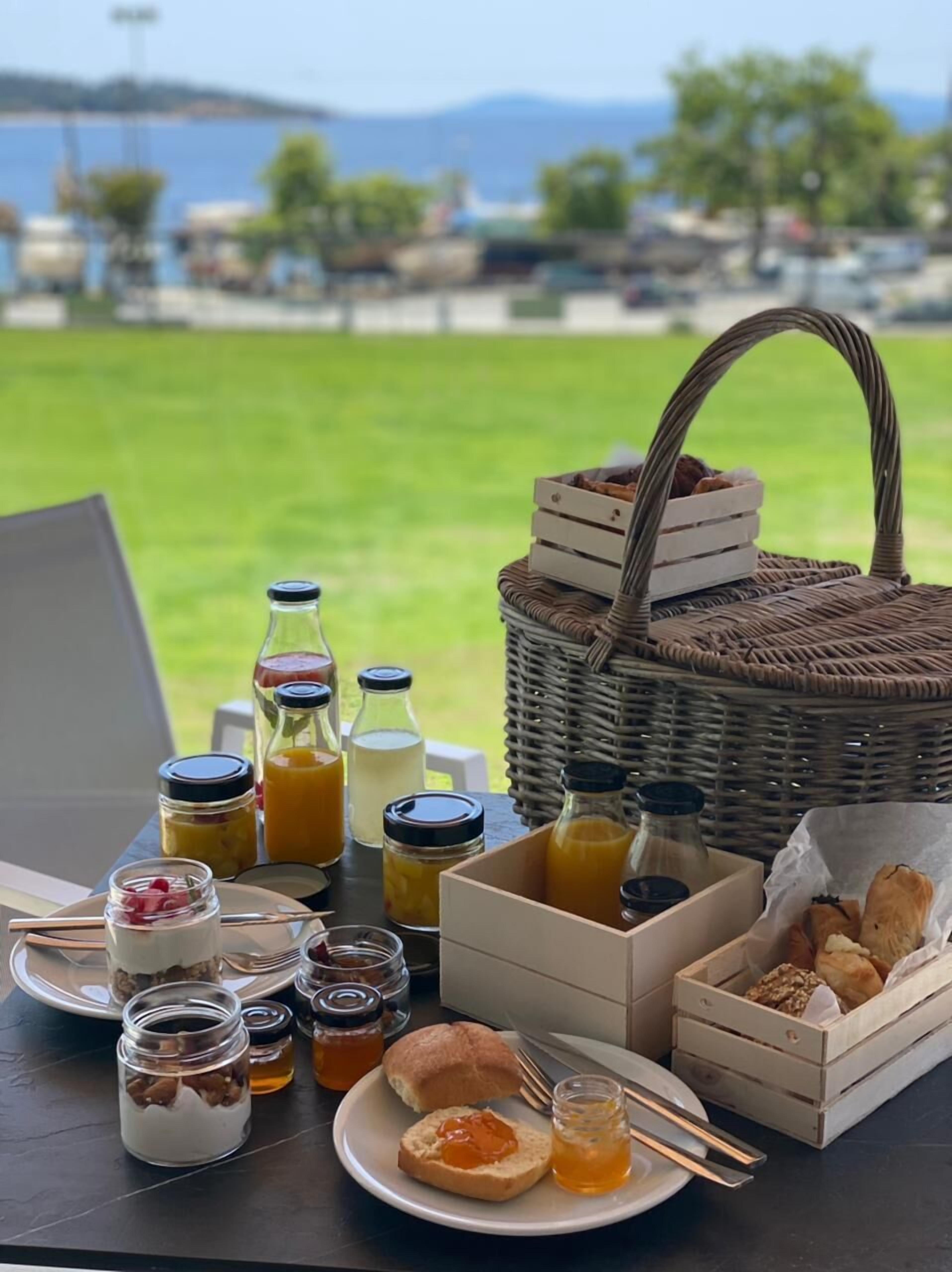 Een ontbijt opstelling met diverse soorten eten en drinken op een tafel, met uitzicht op een prachtig landschap.