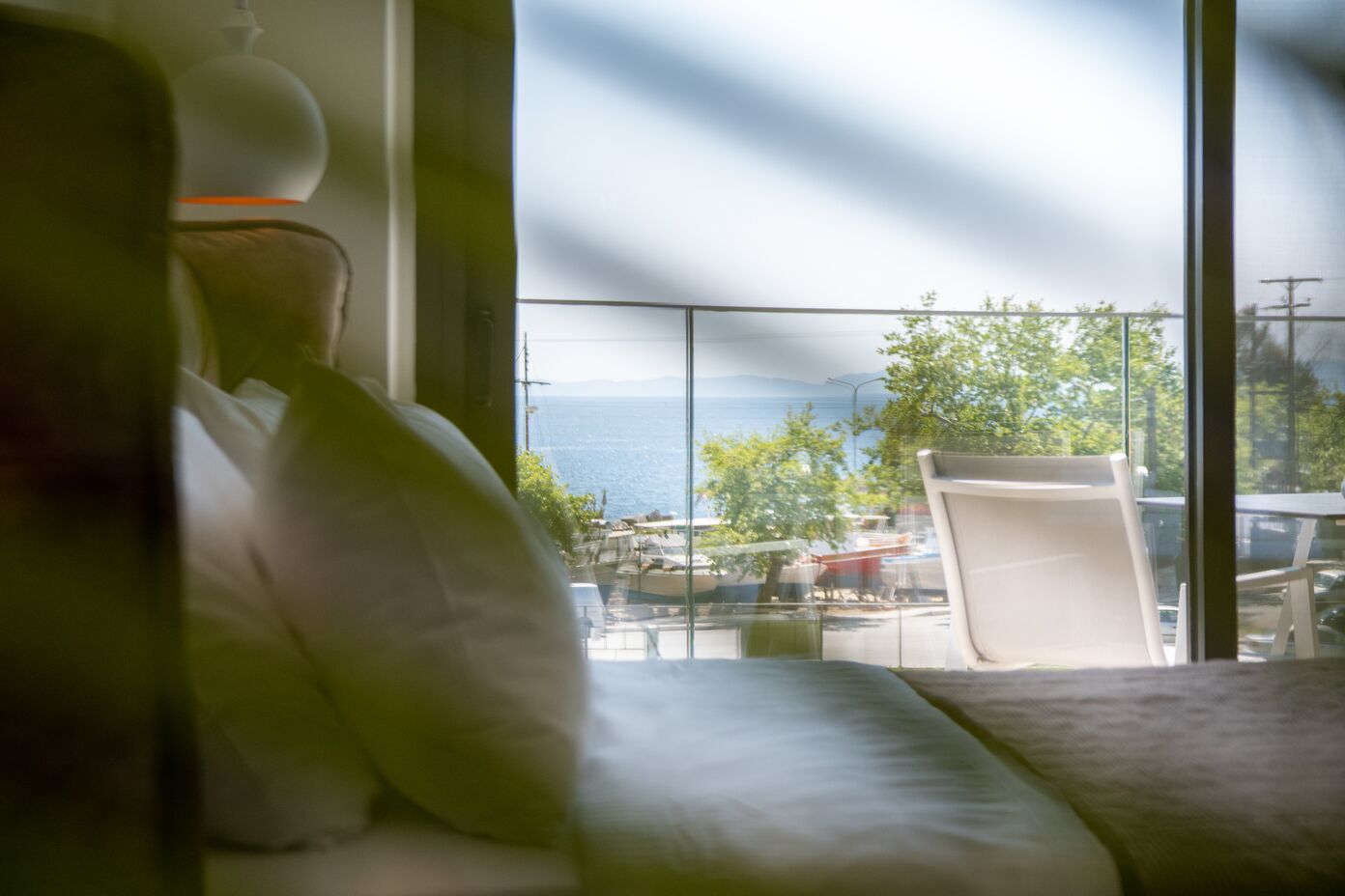 Ein Balkon mit Meerblick, ein weißer Stuhl und ein Tisch.