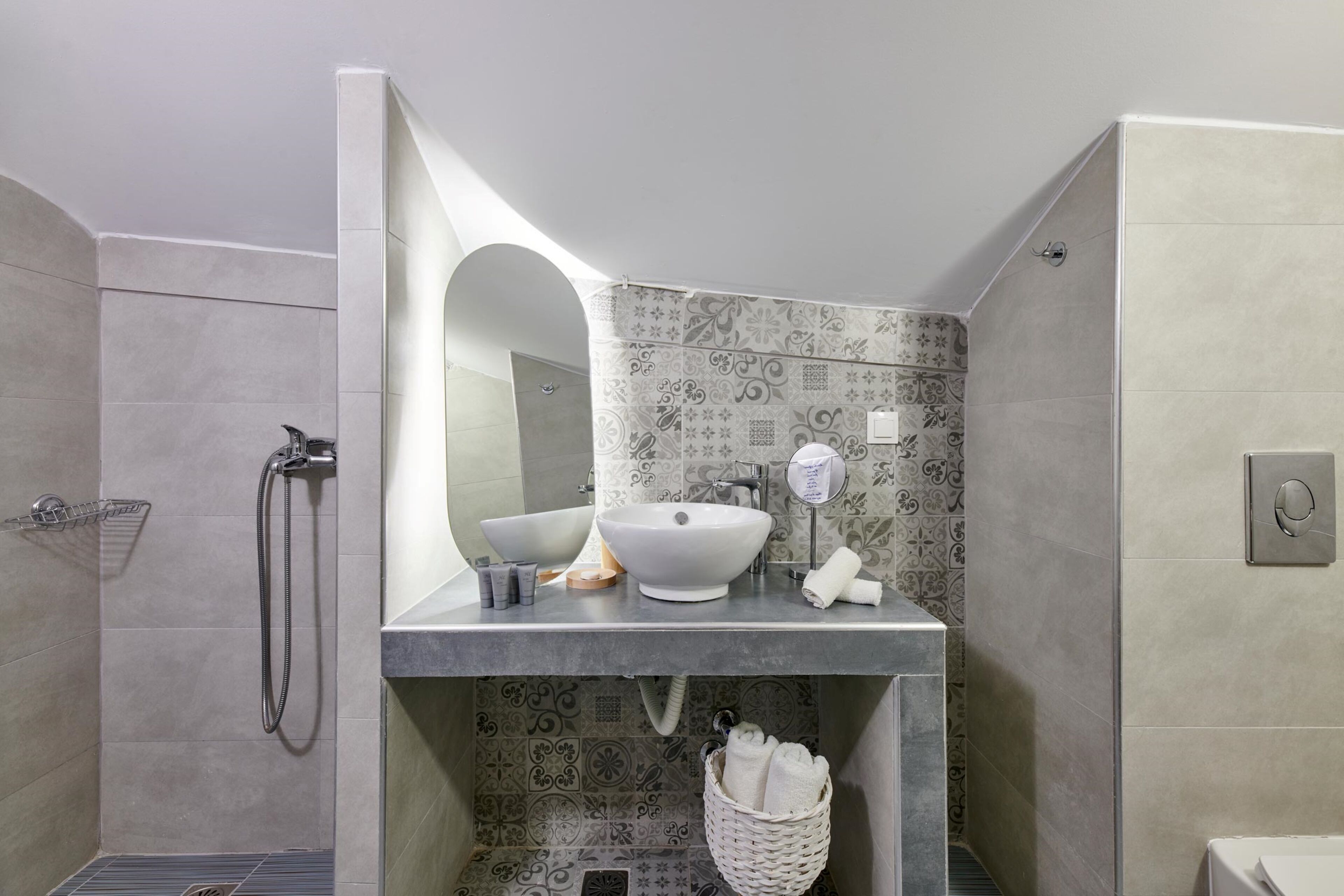A modern bathroom with a large mirror, two sinks, a shower, and a towel rack.
