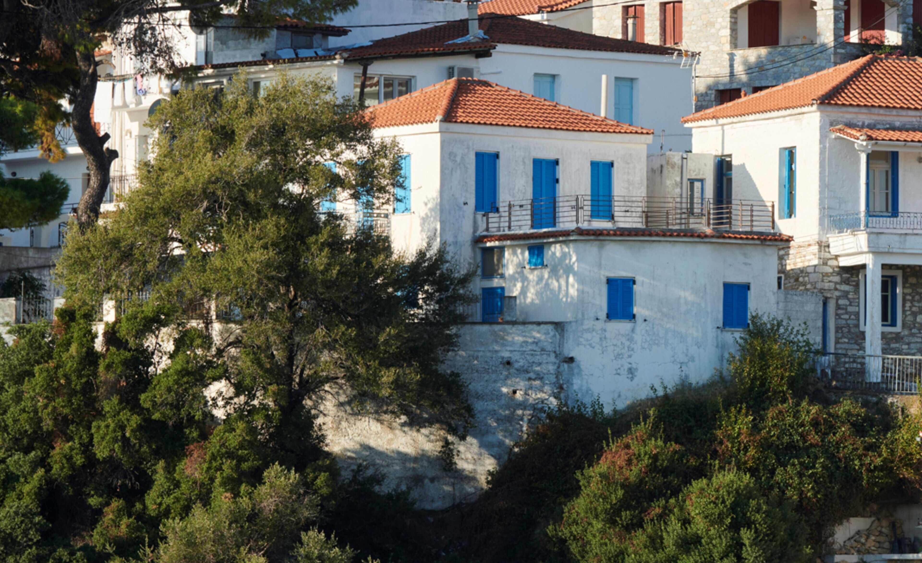 Un bâtiment situé sur la côte, à plusieurs étages, avec des murs blancs et des toits recouverts de tuiles rouges.