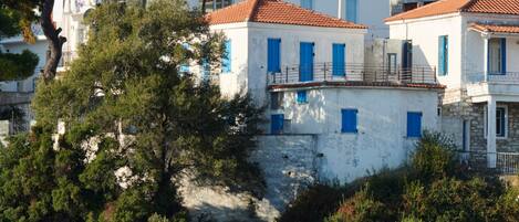 Un bâtiment situé sur la côte, à plusieurs étages, avec des murs blancs et des toits recouverts de tuiles rouges.