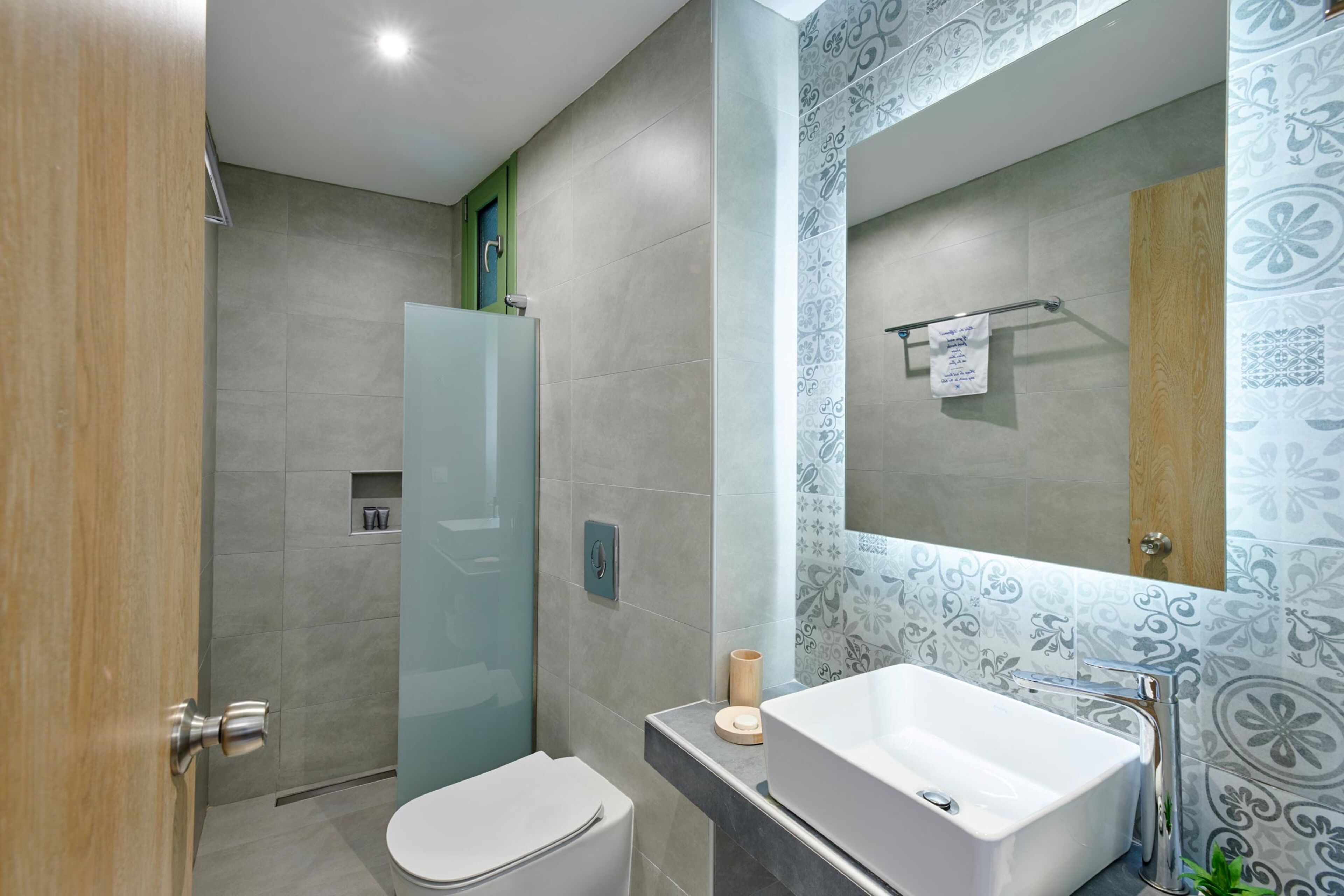 A modern bathroom with a toilet, sink, and shower.