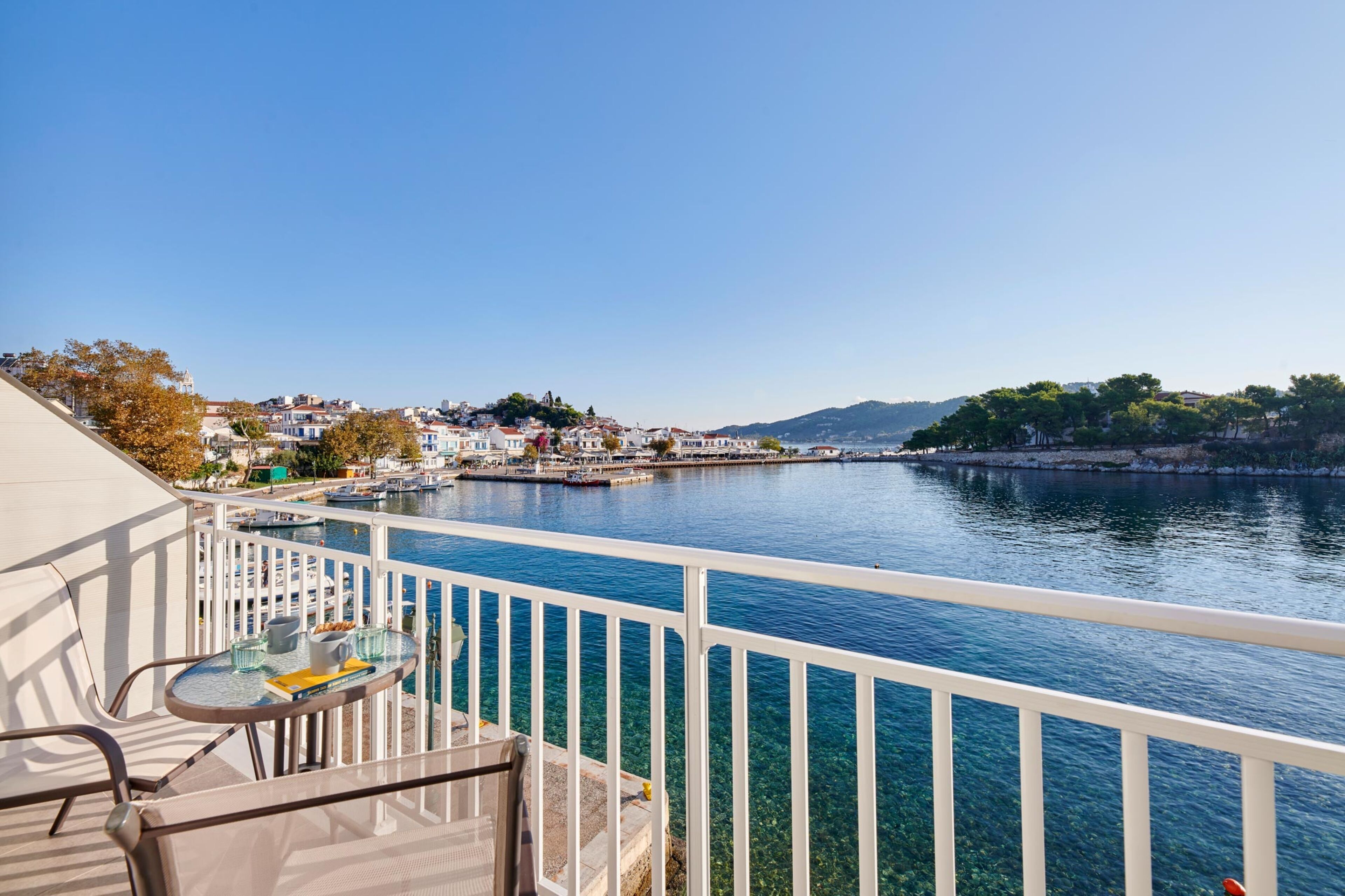 A balcony with a clear view of a waterfront, including a marina and buildings in the background.