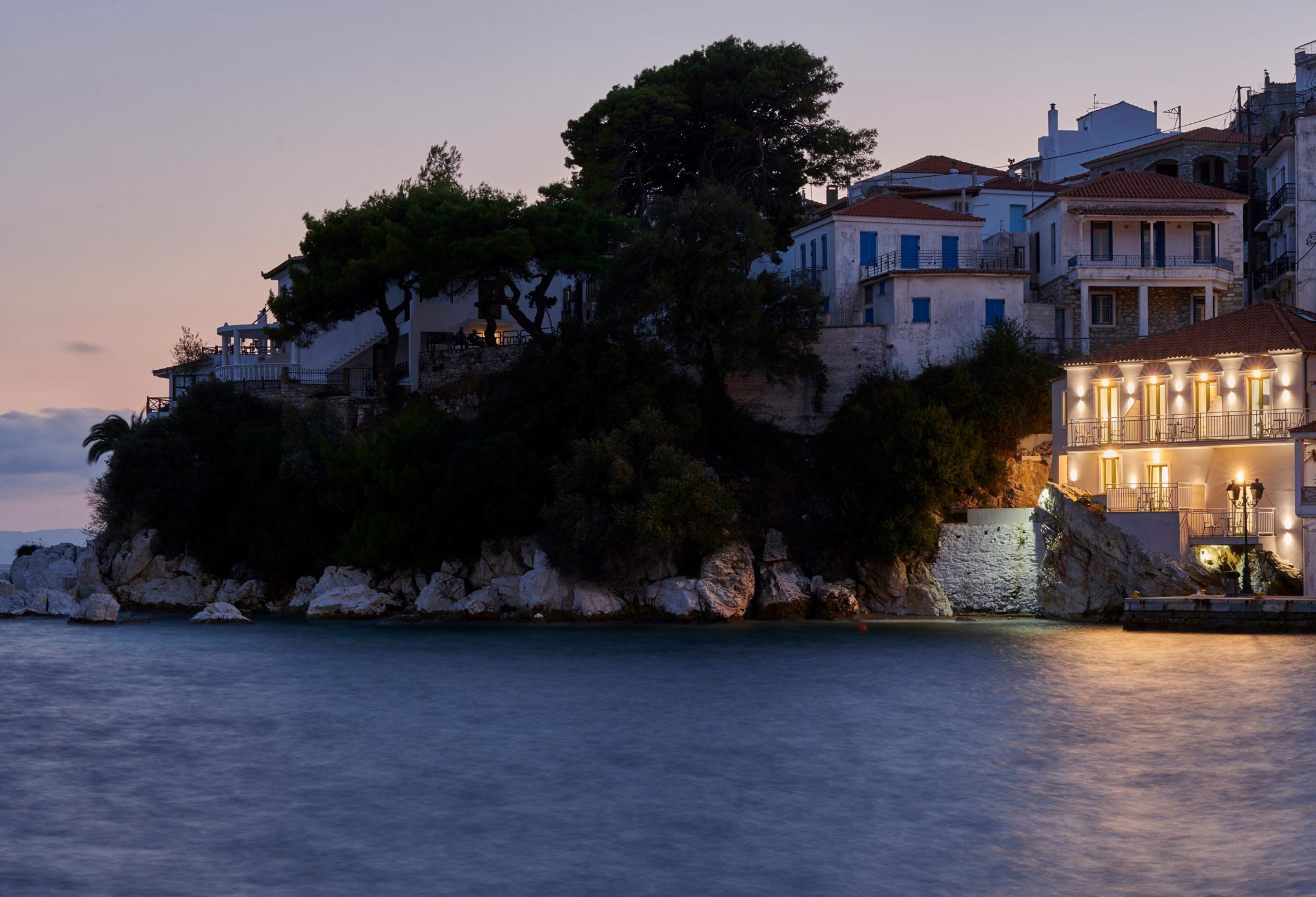 A coastal building with multiple balconies and a stone wall.