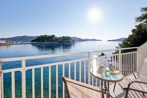 A balcony with a clear view of a calm sea, a distant island, and a mountainous backdrop. - The Water Suites (Skiathos)