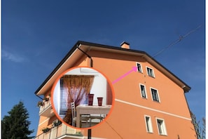 A building with a balcony, a window, and a door.