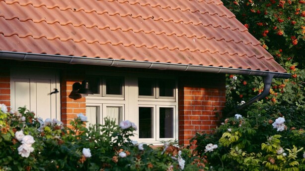 A house with a red tiled roof, white window frames, and a brick wall. - Vacation home 2 - Holiday homes Michaelis 1 to 4 in Quilitz (Rankwitz)