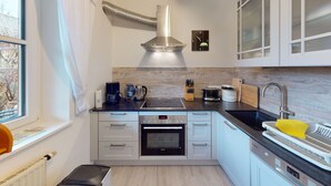 A modern kitchen with a built-in oven, a coffee maker, and a sink with a dish rack.