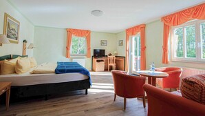 Een kamer met een bed, een bureau, een stoel en een tafel.