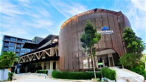 Un edificio moderno con fachada curva y un cartel que dice "PHUDAHL".