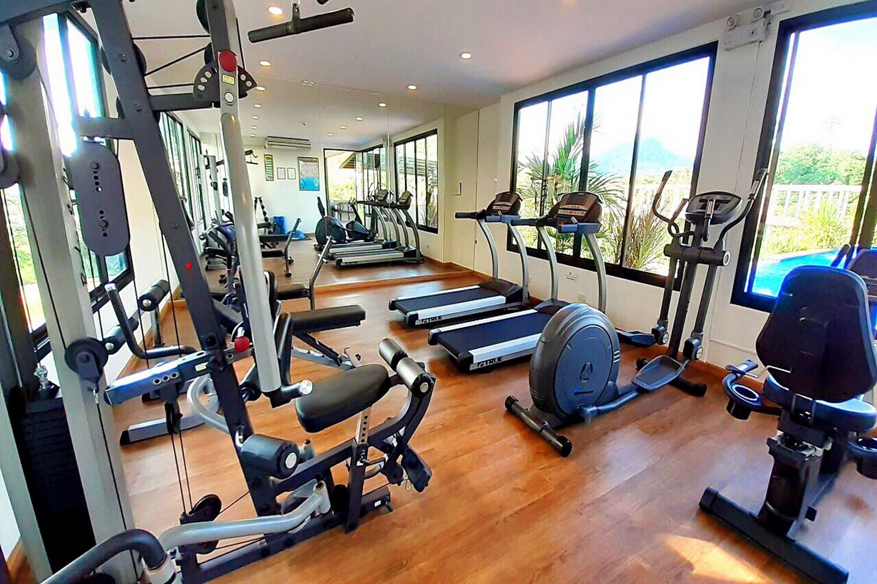 Un gimnasio con cintas de correr, máquinas de pesas y equipo cardiovascular.