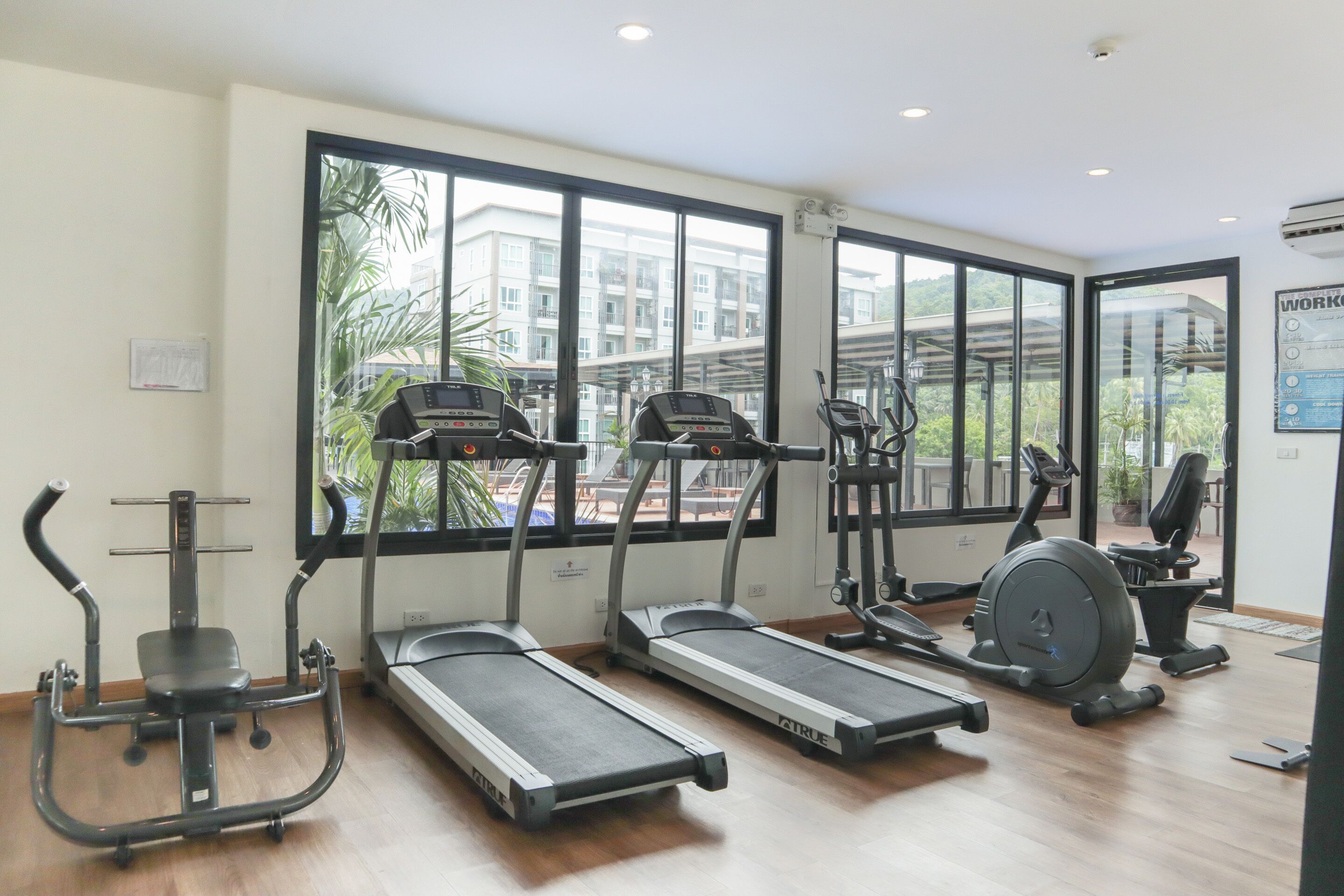 A gym with treadmills, an elliptical, and a stationary bike.