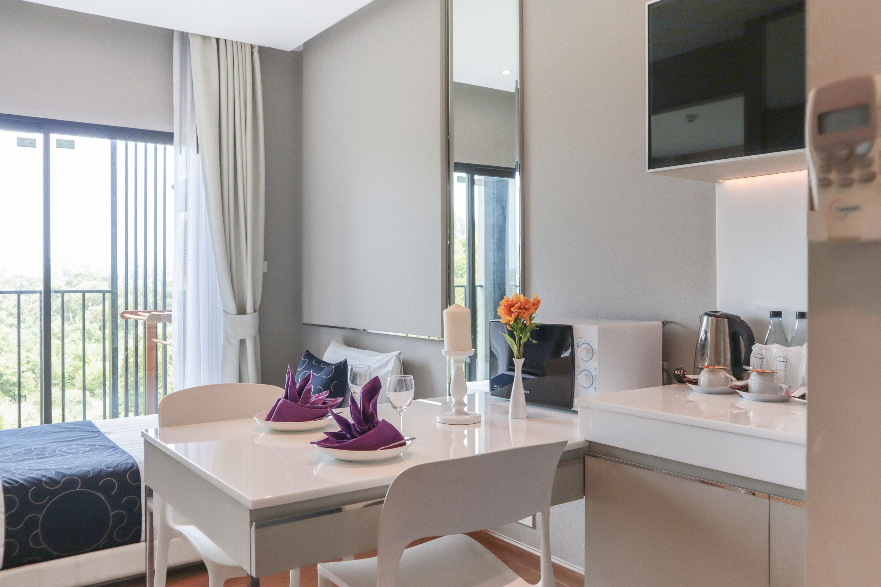 Une chambre d’hôtel comprenant un lit, une table à manger avec des chaises, une machine à café et un téléviseur.