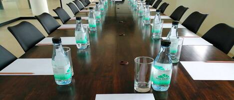 A conference room with a long table, black chairs, and water bottles labeled "PHU DAHL RESIDENCES".