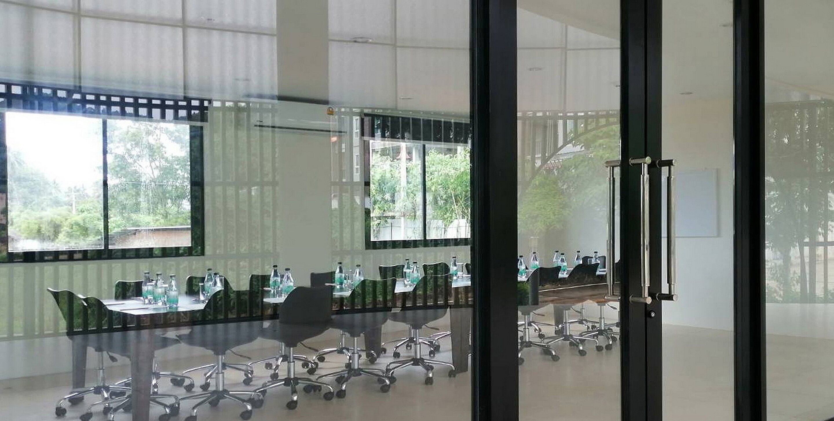 A conference room with a long table, chairs, and water bottles.