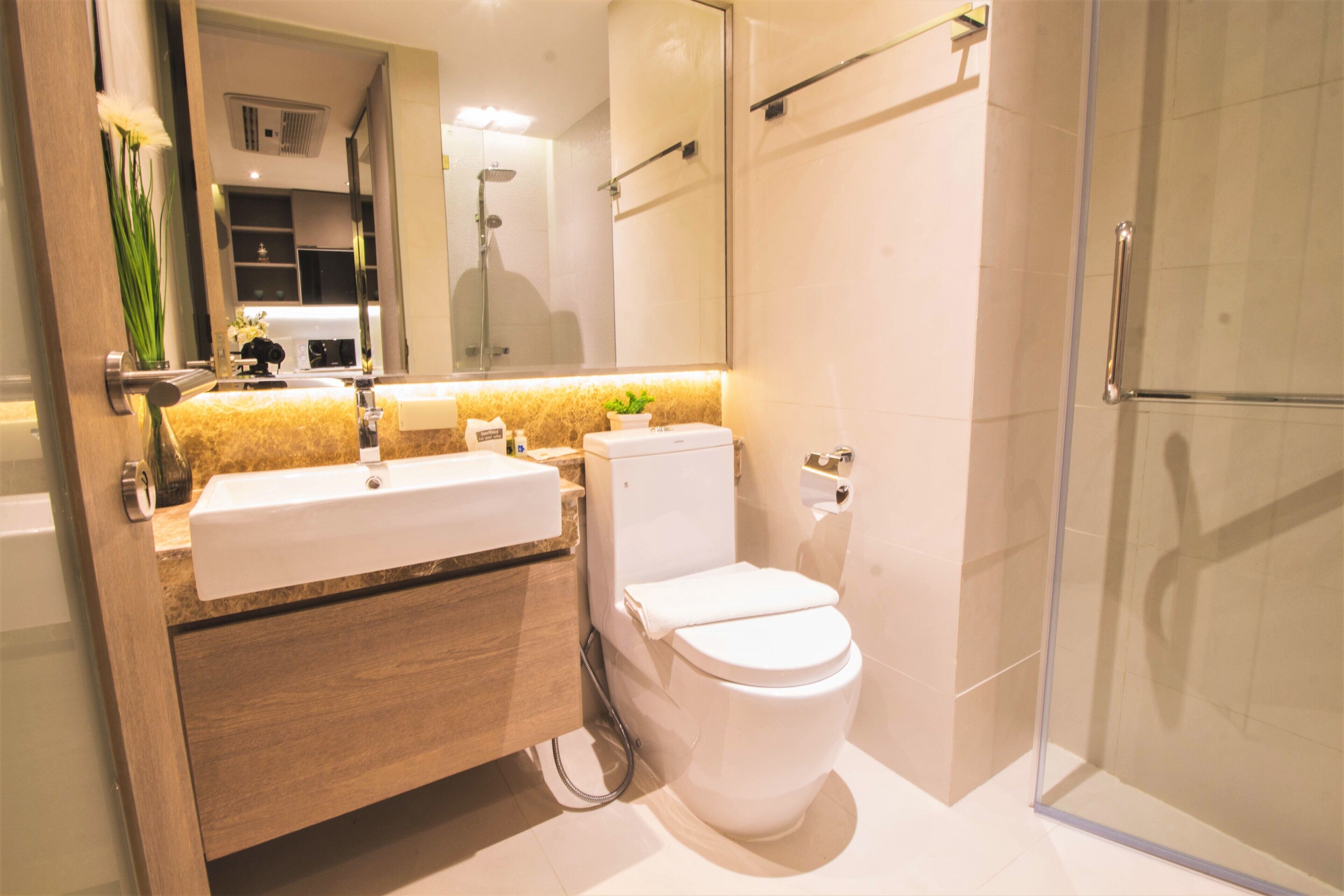 Une salle de bain moderne avec un lavabo, des toilettes et une douche.