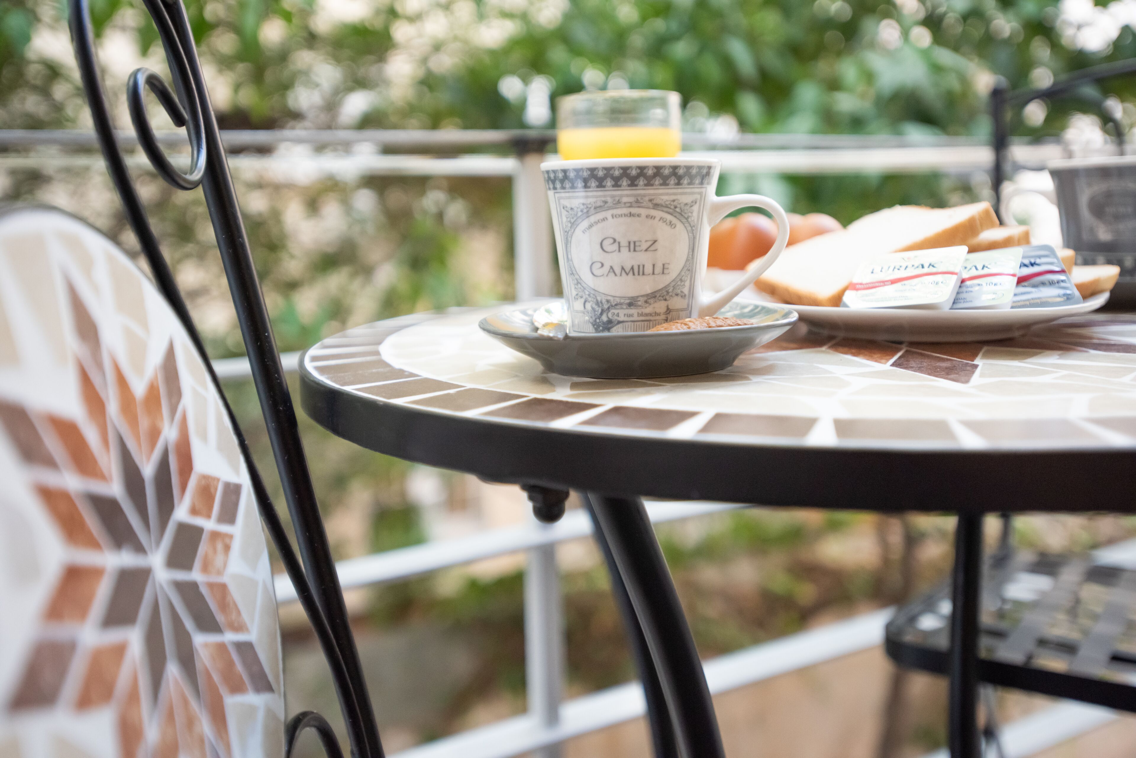A dining table with a plate of food, a mug, and a glass of orange juice.