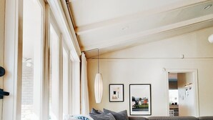 Un salon moderne avec un canapé d’angle, une table basse et une grande fenêtre qui laisse entrer la lumière naturelle.