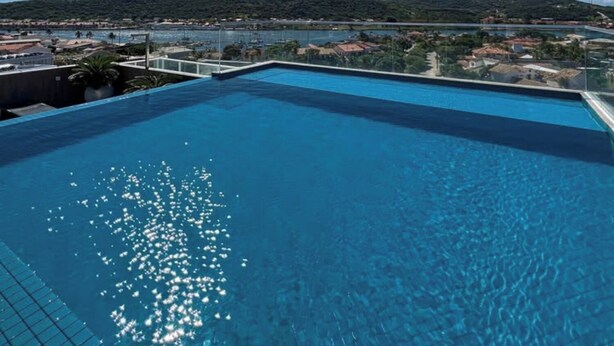 Ein klarer, blauer Himmel, ein Schwimmbecken und Blick auf eine hügelige Landschaft.