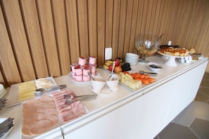 Enjoy a spread of sliced meats, fresh fruits, and refreshing beverages at this inviting buffet.