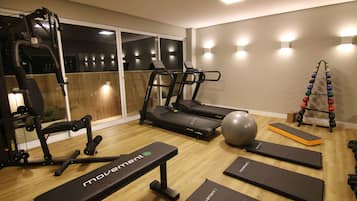 A home gym with treadmills, a stationary bike, a rowing machine, and various exercise mats.