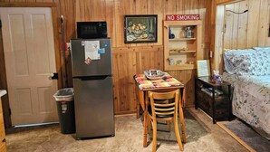 A compact kitchen with a refrigerator, microwave, and a 'No Smoking' sign. - Cozy studio cabin close to Lake Michigan. (Frankfort)