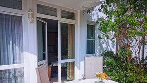 A patio with a table and chairs, a potted plant, and a view of the interior through glass doors. - 2 Room C 7 - Wohnpark Binz (with indoor pool) (Binz)