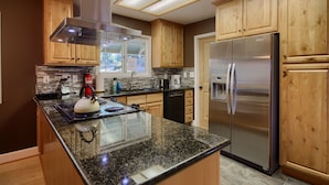 A modern kitchen with wooden cabinets, stainless steel appliances, and a granite countertop. - The Retreat@Lakeside Hot Tub/Views/Fast WiFi Near Yosemite! (Mariposa)