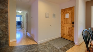 A hallway with a wooden door, a rug, and a stone wall. - The Retreat@Lakeside Hot Tub/Views/Fast WiFi Near Yosemite! (Mariposa)