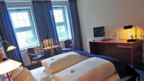 A hotel room with a bed, a desk, a chair, and a TV. - Double room 05 - Hotel Goldene Krone (Clausthal-Zellerfeld)