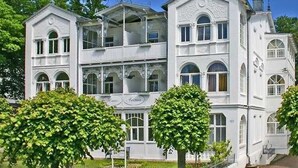 A multi-story white building with balconies and arched windows. - 15 Ferienappartement Mönchgut (A) - Apartment house Haus Arkona (Sellin)