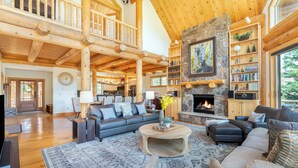 A spacious living room with a fireplace, wooden beams, and a cozy seating area. - MOUNTAIN MELODY- A Luxury Music Paradise, On Elks Pond, Hot Tub, Oxygen Bar (Telluride)