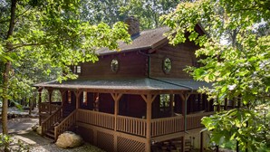 A wooden cabin with a porch, surrounded by trees. - Luxury cabin in the woods, 2 bedrooms plus loft (Fairfield)