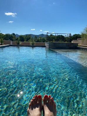Une piscine aux eaux cristallines, avec une vue sur les montagnes en arrière-plan.