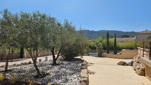 A landscaped outdoor area with trees, a pool, and a view of mountains. - Beautiful villa with two swimming pools—one outdoor and one indoor—and a Jacuzzi (Hérépian)