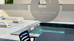 Logo für 'LES VILLAS BLACK&WHITE' mit einem Haus-Symbol, einer Poolanlage mit Liegestühlen und einem gefliesten Pool.