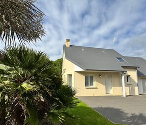 A two-story house with a grey roof, a small balcony, and a well-maintained lawn. - HOUSE NEAR THE SEA (Portbail)