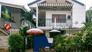 A two-story building with a balcony and a covered outdoor seating area. - Roccksar Pension (Puerto Princesa)