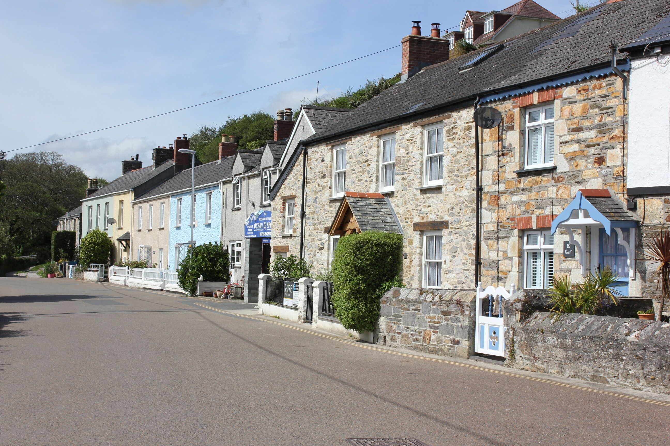 A row of traditional stone buildings with a clear road in front.