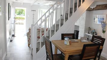 A staircase leading to a dining area with a wooden table and chairs.