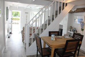 A staircase leading to a dining area with a wooden table and chairs.